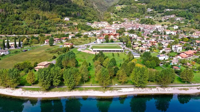Aerial view of a lakeside town surrounded by green hills.