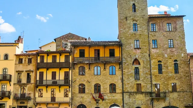 Historic Italian buildings under a clear blue sky.