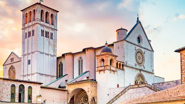 Historic stone basilica under a colorful sunrise sky.