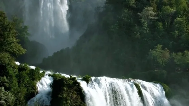 Waterfall cascading through lush green forest.
