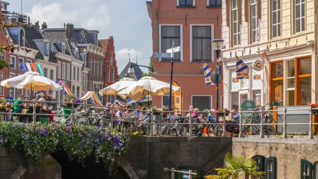 Canal in a charming city with outdoor cafes and colorful buildings.