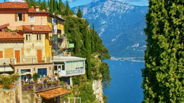 Hilltop houses overlooking a blue lake with mountains in the background.