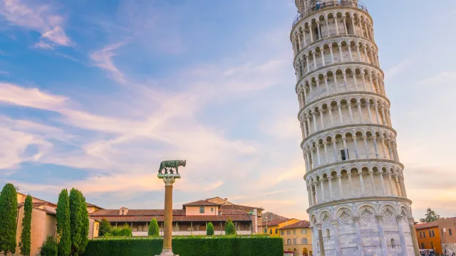 Leaning Tower of Pisa on a sunny day, green lawn, and blue sky.