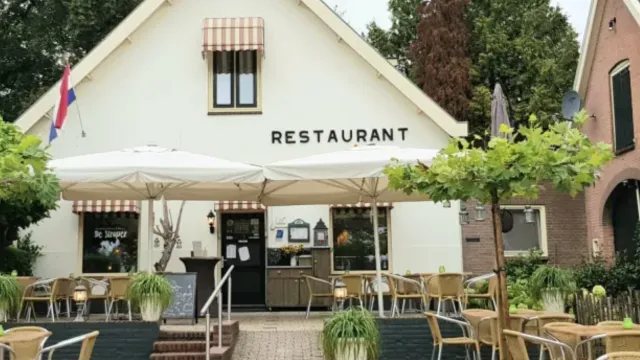 Cozy outdoor restaurant with patio seating and white umbrellas.