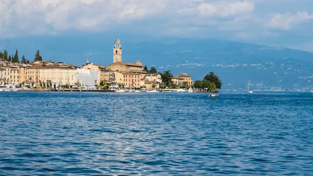 Lakeside town with distant mountains and cloudy sky.