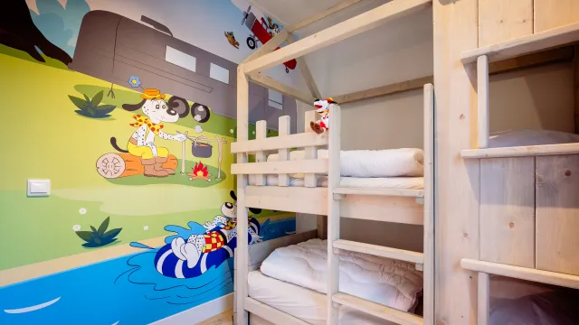 Bunk bed in a colorful kids' room with cartoon mural.