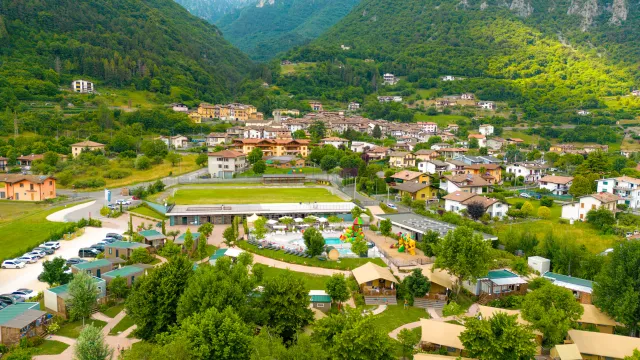 Aerial view of a village surrounded by green hills and lush mountains.