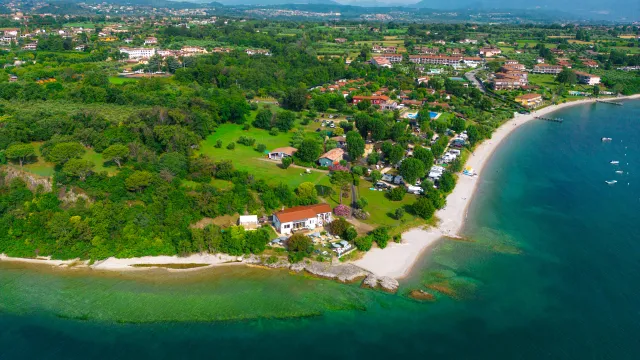 Coastal town with green landscape and sandy beach.
