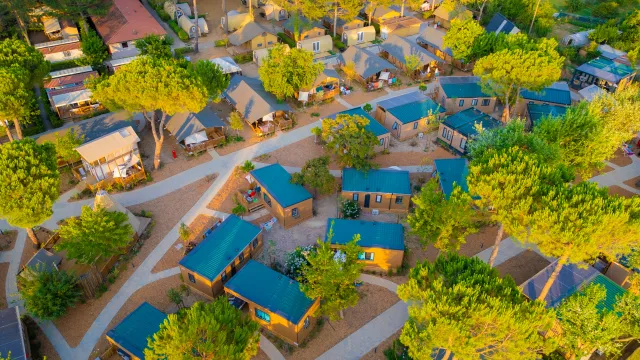 Aerial view of a campground with cabins and trees.