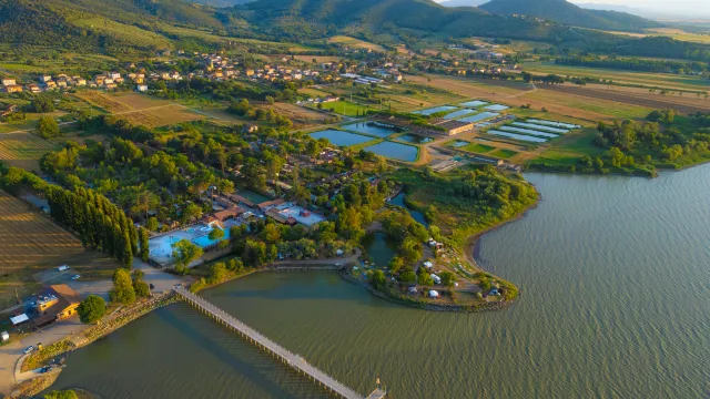 Aerial view of a lakeside town with mountains in the background.