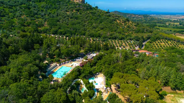 Aerial view of a lush green landscape with a hilltop village.