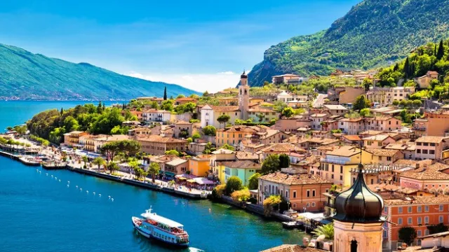 Colorful coastal town with mountains and a blue lake.