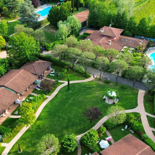 Aerial view of lush green garden with pools and pathways.