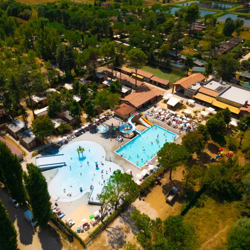 Aerial view of a resort with two pools and surrounding greenery.