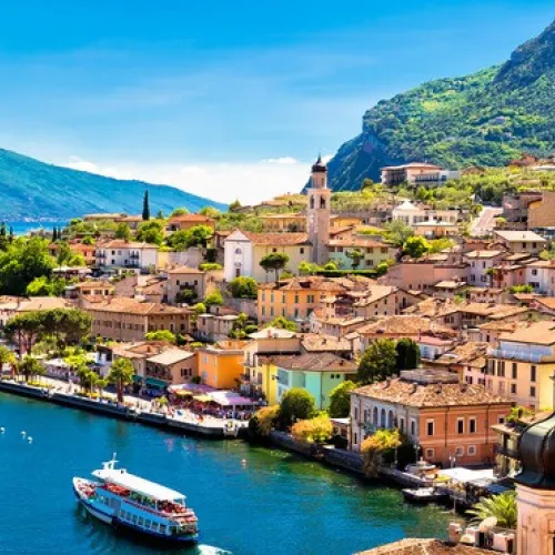 Colorful coastal town with mountains and a blue lake.