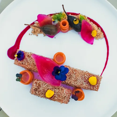 Elegant plated dish with vibrant garnish and colorful presentation.