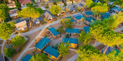 Aerial view of a campground with cabins and trees.