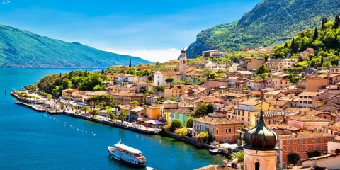 Colorful coastal town with mountains and a blue lake.