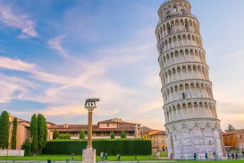 Leaning Tower of Pisa on a sunny day, green lawn, and blue sky.