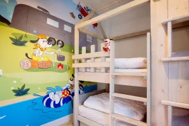 Bunk bed in a colorful kids' room with cartoon mural.