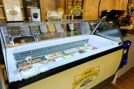 Gelato counter with assorted flavors in a shop.