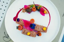 Elegant plated dish with vibrant garnish and colorful presentation.