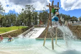 Water slide and splash area with children playing.