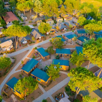 Aerial view of a campground with cabins and trees.