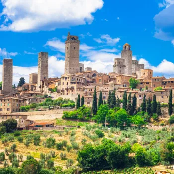 Medieval town with stone towers under a bright blue sky.