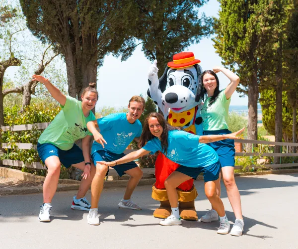 Persons posing playfully with a costumed character outdoors.