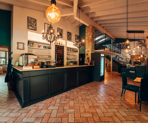 Cozy restaurant interior with wooden bar and warm lighting.