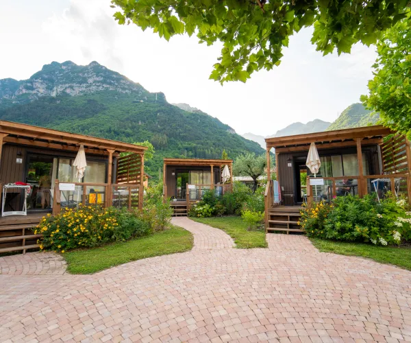 Cozy cabins with lush gardens and mountain backdrop.
