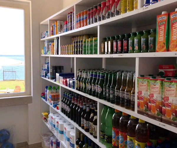 Bottles and cartons on shelves in a small room with a window.