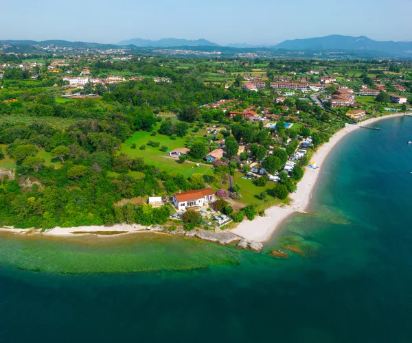 Aerial view of a coastal village with green fields and sandy beaches.