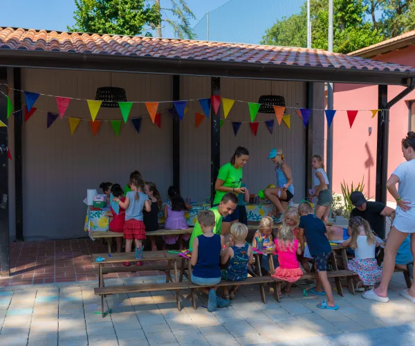 Children playing under colorful bunting in an outdoor setting.