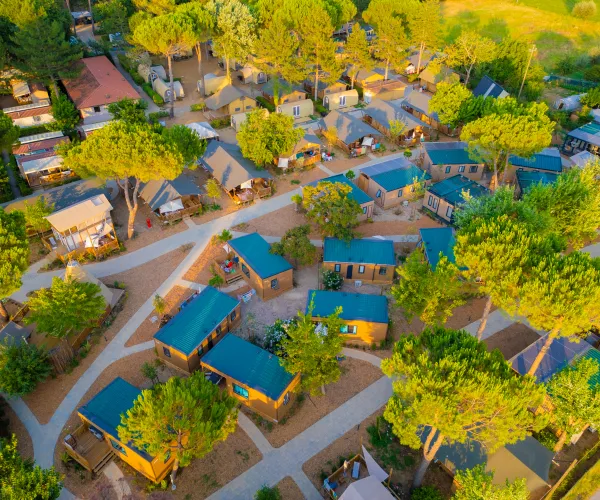Aerial view of a campground with cabins and trees.