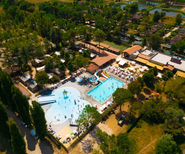Aerial view of a resort with two pools and surrounding greenery.