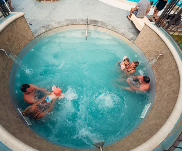 People relaxing in a circular hot tub, seen from above.