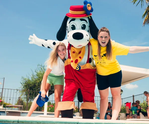 spotty with two women by a pool, under a sunny sky.
