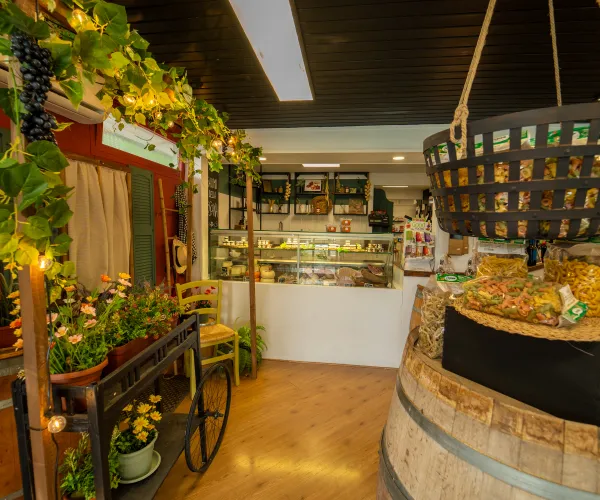 Cozy interior of a deli with wooden barrels and hanging lights.