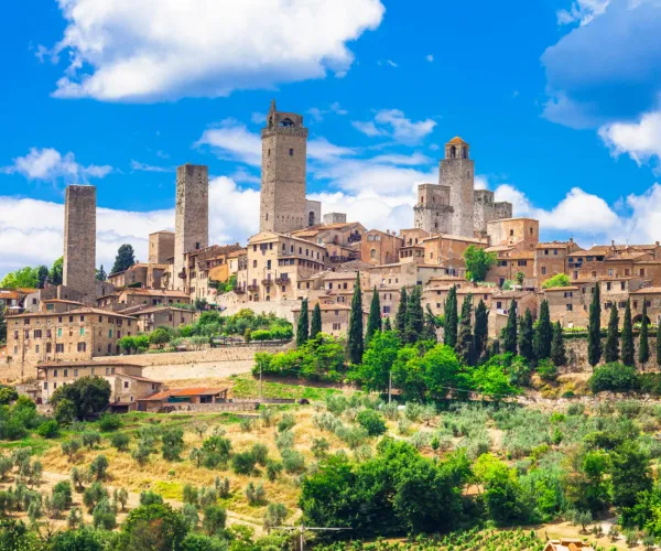 Medieval town with stone towers under a bright blue sky.